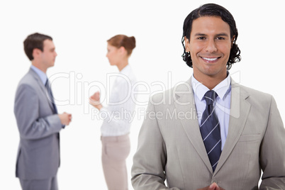 Businessman with talking colleagues behind him