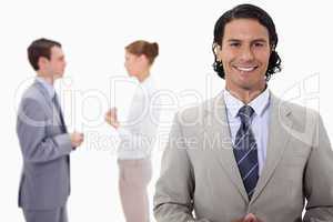 Businessman with talking colleagues behind him