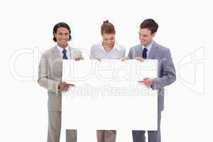 Businessteam pointing at blank sign in their hands