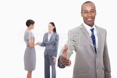 Smiling businessman offering his hand with hand shaking colleagu