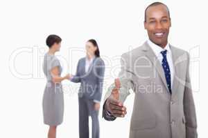 Smiling businessman offering his hand with hand shaking colleagu