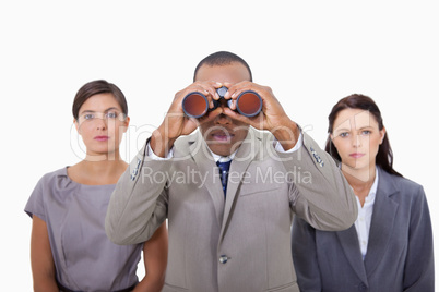 Businessman with colleagues using binoculars