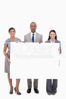 Businesspeople holding blank sign