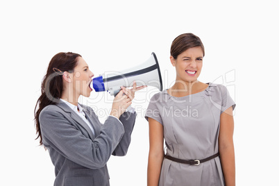 Businesswoman with megaphone yelling at colleague