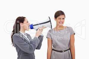 Businesswoman with megaphone yelling at colleague