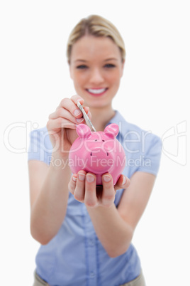 Note being put into piggy bank by woman