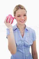 Smiling woman shaking her piggy bank