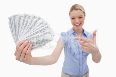 Money being held and pointed at by woman