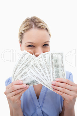 Woman hiding behind bank notes