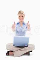 Sitting woman with laptop giving thumbs up