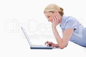 Side view of smiling woman using her laptop