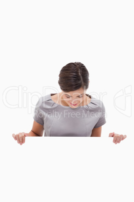 Woman looking down on blank wall