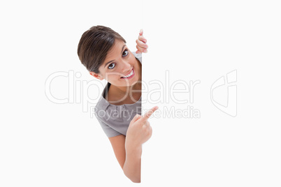 Smiling woman pointing around the corner