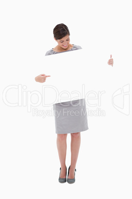 Woman pointing at blank sign in her hands