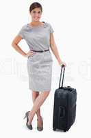 Woman standing next to wheely bag