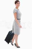 Side view of smiling woman with wheely bag