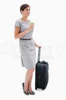 Side view of woman with coffee and wheely bag