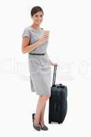 Smiling woman with coffee and wheely bag