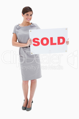 Woman holding sold sign in her hands