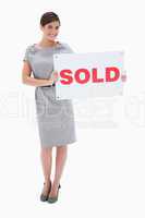 Woman holding sold sign in her hands