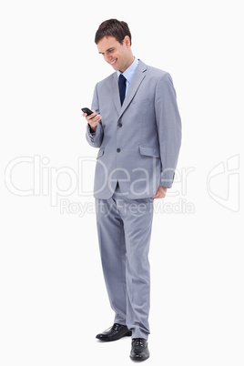 Smiling businessman reading text message