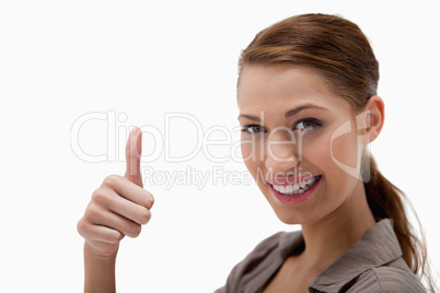 Side view of smiling woman giving thumb up