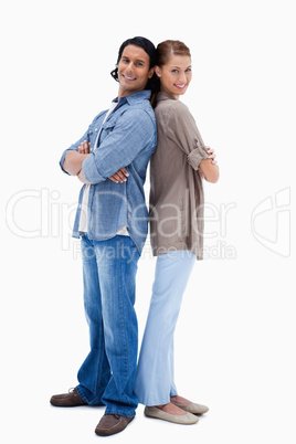 Smiling young couple standing back to back