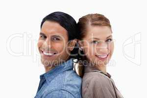 Side view of smiling couple standing back to back