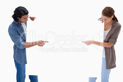 Couple looking and pointing at blank sign in their hands