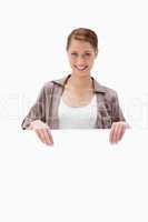 Smiling woman holding blank signboard