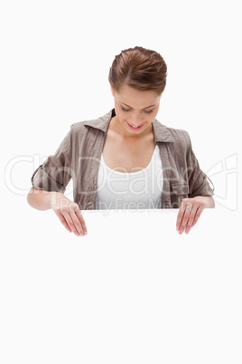 Woman looking down at blank signboard
