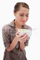 Woman smelling on her bowl of fruit salad
