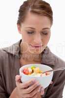 Woman smelling on bowl of fruit salad