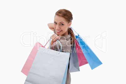 Side view of smiling woman with shopping bags