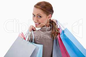 Back view of smiling woman with shopping bags