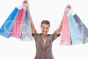 Smiling woman raising her shopping bags