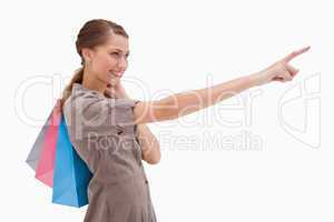 Side view of pointing woman with shopping bags