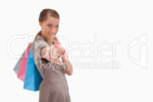 Hand of woman with shopping bags pointing