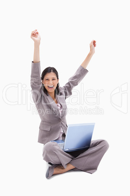 Cheering woman sitting with laptop