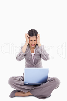 Sitting woman having trouble with notebook