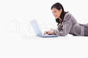 Side view of lying woman with laptop