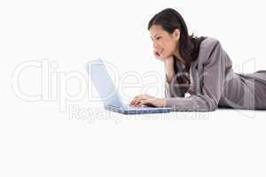 Side view of lying woman using laptop