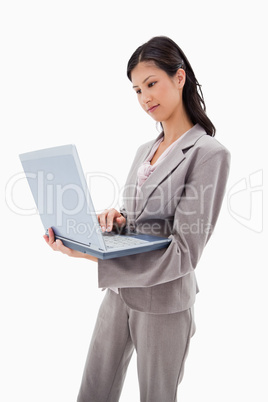 Side view of businesswoman standing with laptop