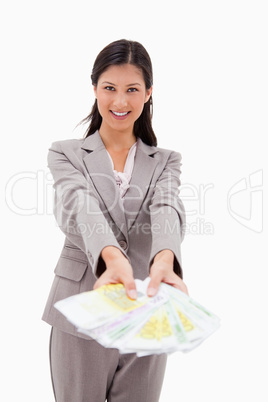 Smiling businesswoman offering money