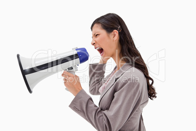 Side view of angry businesswoman yelling through megaphone