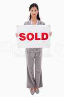 Real estate agent holding sold sign
