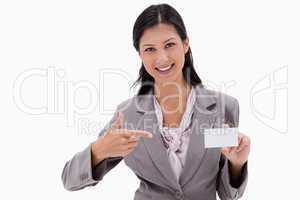 Smiling businesswoman pointing at blank business card