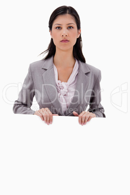 Serious looking businesswoman with blank sign board