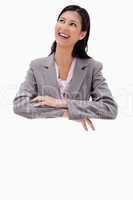 Smiling businesswoman leaning on a blank wall
