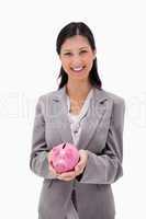 Smiling businesswoman with piggy bank